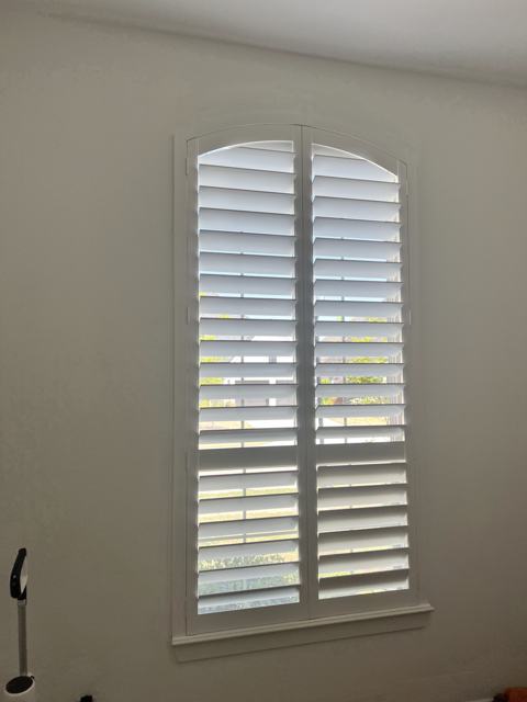 Arched plantation shutters on a tall window